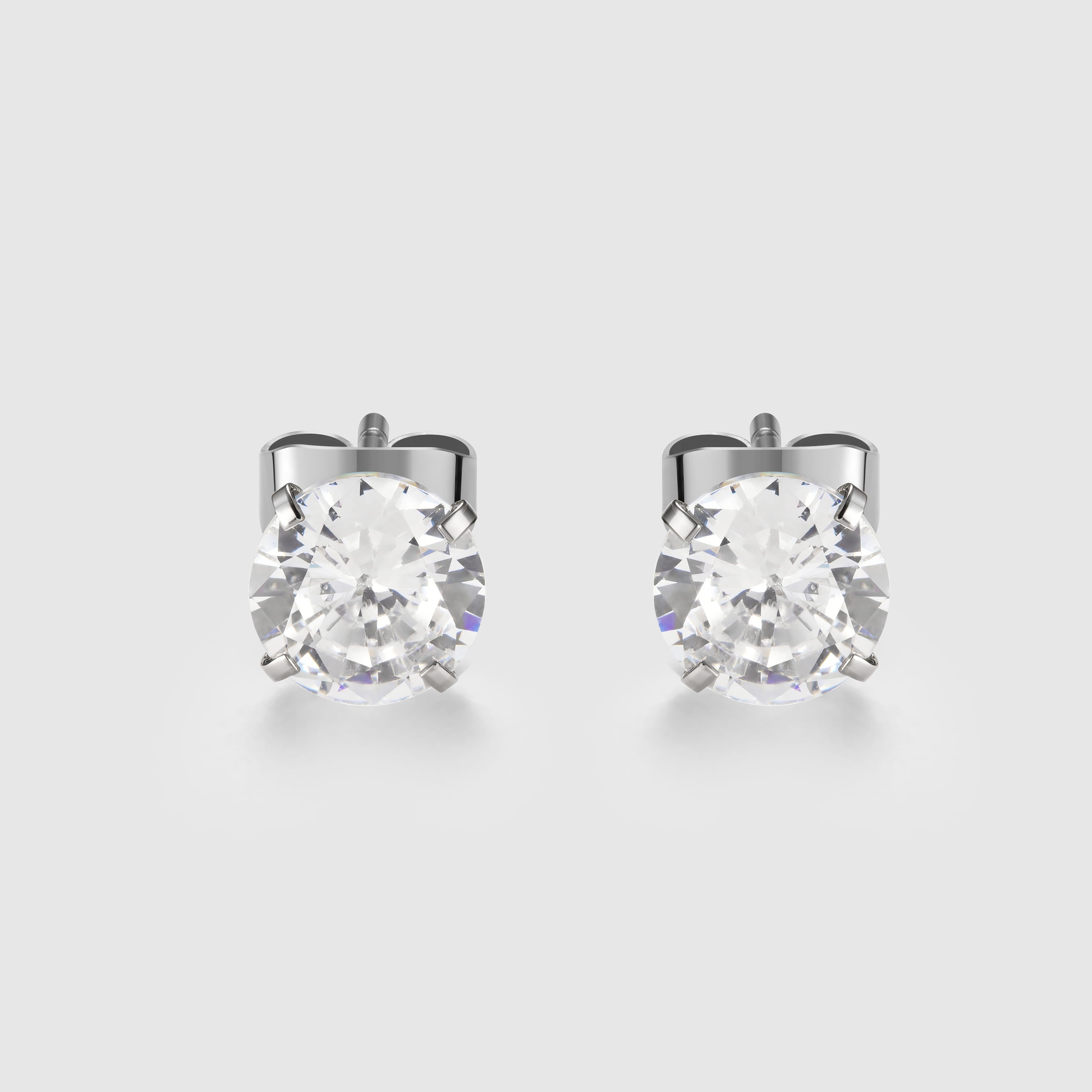 Pair of silver stud earrings with clear gemstones on a light gray background