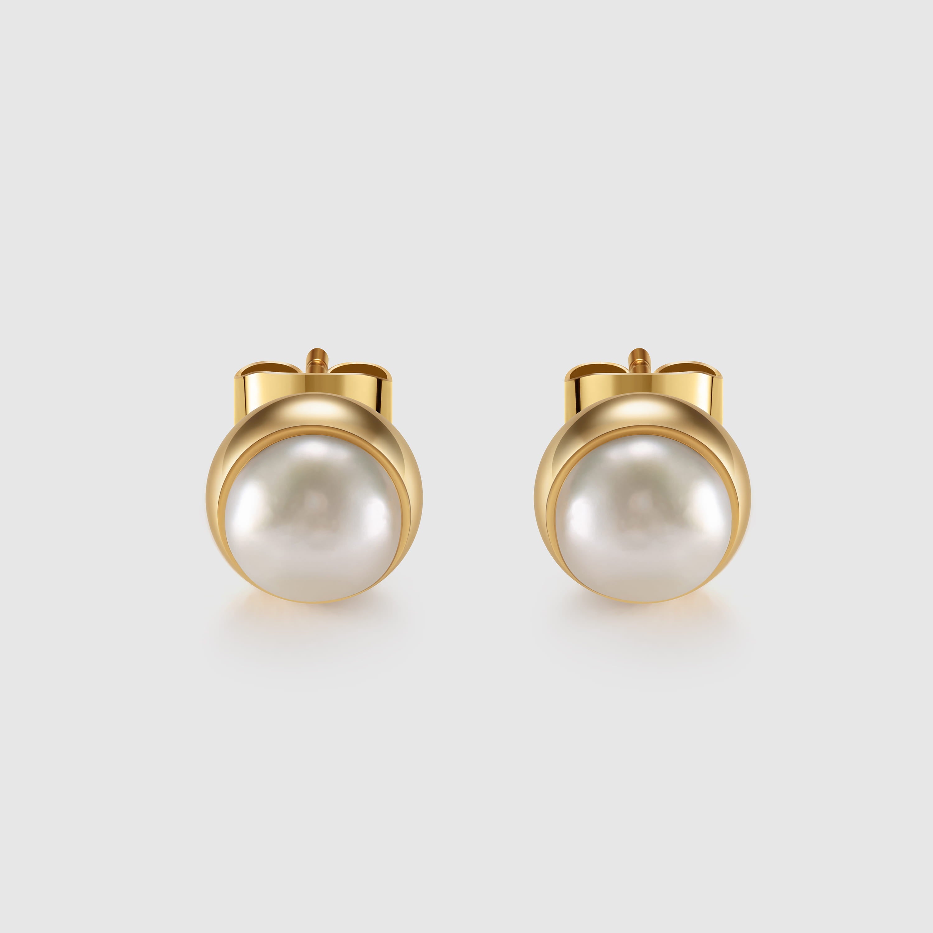 Pair of pearl earrings with gold posts on a light gray background