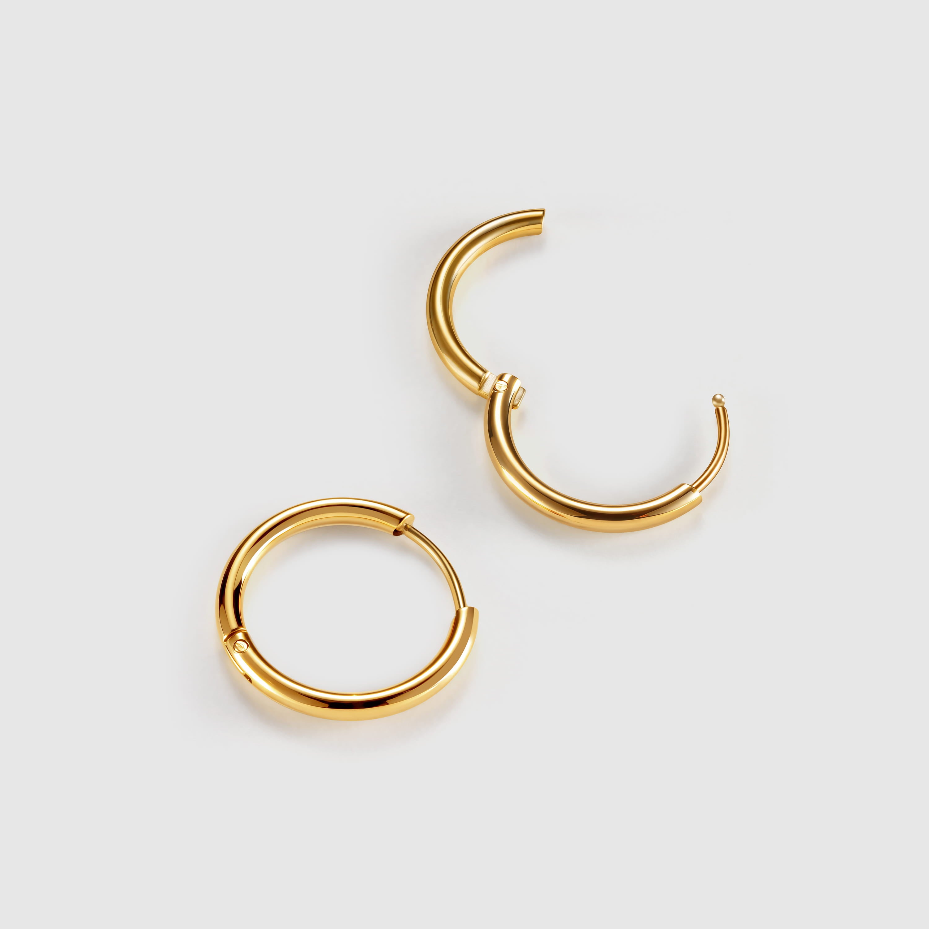 Gold hoop earrings on a light gray background