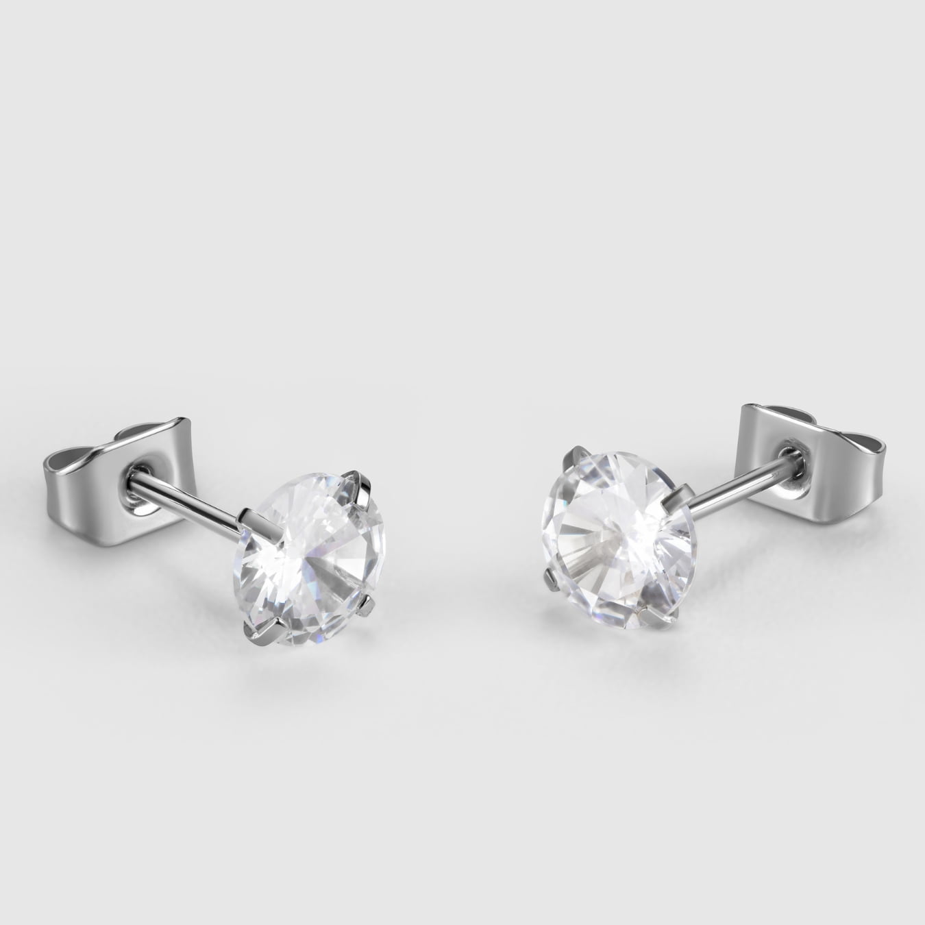 Pair of silver stud earrings with clear gemstones on a light gray background