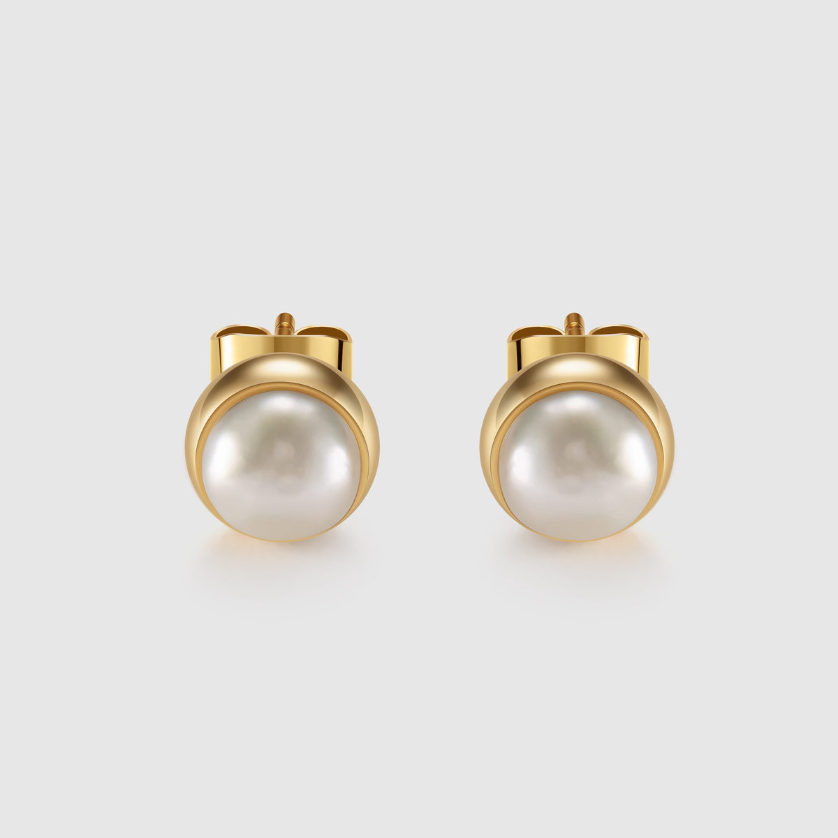 Pair of pearl earrings with gold posts on a light gray background